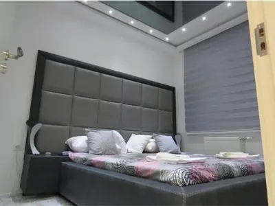 a bed with a large headboard in a bedroom at Harmony in Niš