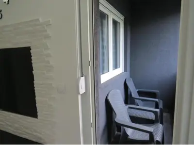 two chairs sitting in a room with a window at Harmony in Niš