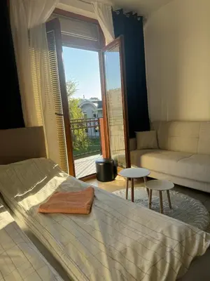 a bedroom with a bed and a couch and a window at Sofi IV in Niš