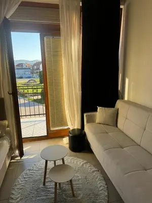 a living room with a couch and a table and a window at Sofi IV in Niš
