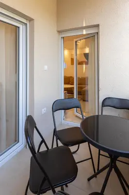 a table and chairs in a living room with a room at Relax in Vranje