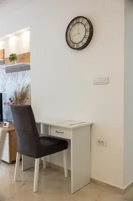 a desk with a chair and a clock on the wall at Relax in Vranje
