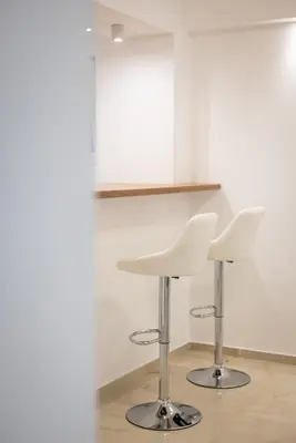 two white chairs and a table in a room at Relax in Vranje