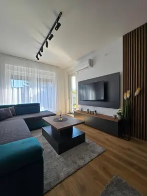 a living room with a couch and a tv at Sunny lux apartman in Vrnjačka Banja