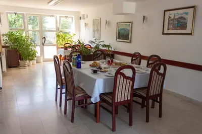 a dining room with a table and chairs with food on it at Vila Lux Milikic in Kraljevo