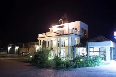 a large building with a balcony on top of it at night at Vila Lux Milikic in Kraljevo