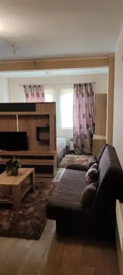 a living room with a couch and a flat screen tv at Mesečeva bajka in Kopaonik