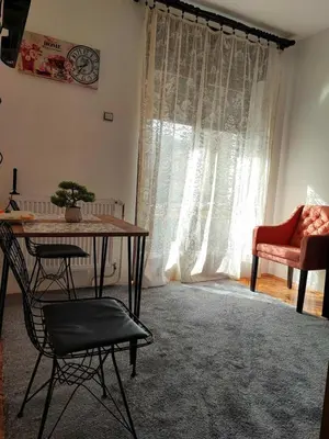 a living room with a table and a chair at Apartmani Varos & Restaurant in Pirot