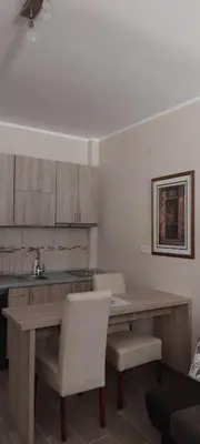 a kitchen with a wooden table and two chairs at Meseceva bajka 2 in Kopaonik