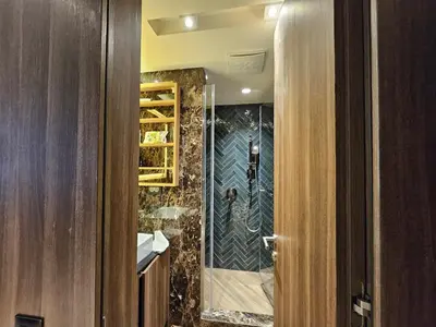 a bathroom with a walk in shower next to a door at Kopaonik Woodside Hotel SKI - SPA in Kopaonik