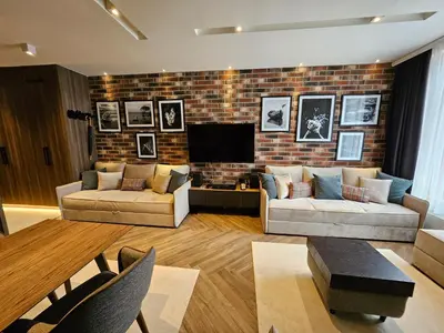 a living room with two couches and a brick wall at Kopaonik Woodside Hotel SKI - SPA in Kopaonik