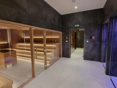 a walk in closet with wooden shelves and a door at Kopaonik Woodside Hotel SKI - SPA in Kopaonik