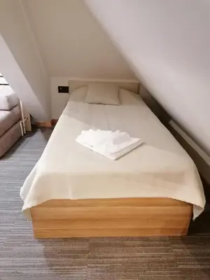 a bed in a small room with a white mattress at Pahulja in Kopaonik