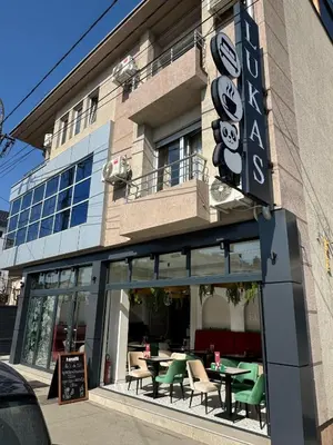 a restaurant with tables and chairs in front of a building at Bed & Coffee LUKAS Krusevac in Kruševac