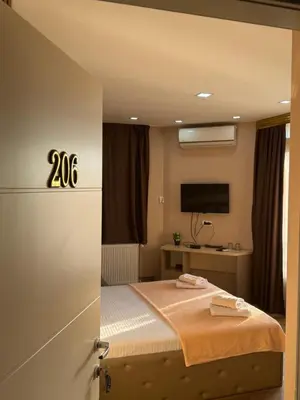 a bedroom with a bed and a television at Bed & Coffee LUKAS Krusevac in Kruševac