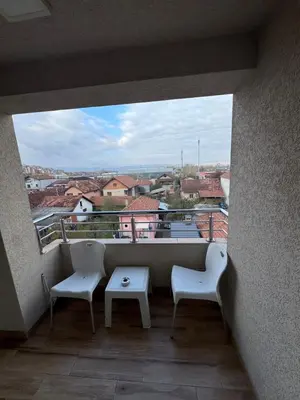 a balcony with two chairs and a table and a view at Bed & Coffee LUKAS Krusevac in Kruševac