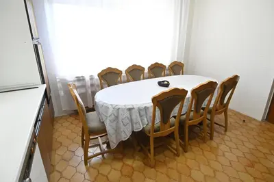 a dining room table with chairs and a white tablecloth at Vikend Kuća Živković in Despotovac