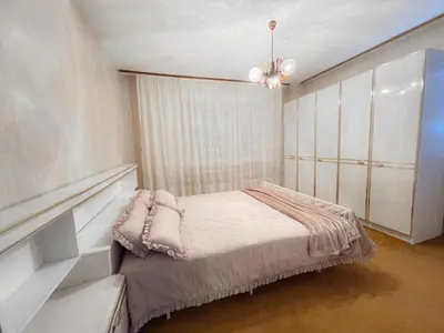 a bedroom with a bed and a chandelier at Vikend Kuća Živković in Despotovac