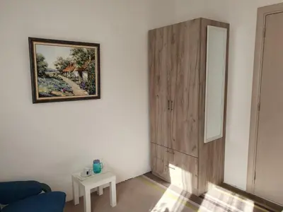 a room with a blue couch and a painting on a wall at Vila LELA in Vrnjačka Banja