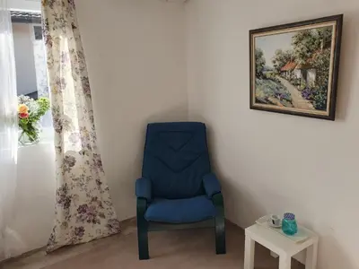 a blue chair sitting in a corner next to a window at Vila LELA in Vrnjačka Banja
