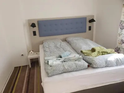 a bed with two blankets and pillows on it at Vila LELA in Vrnjačka Banja