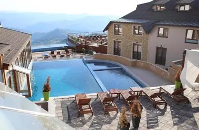 a swimming pool with chairs and a house at Milmari M9 in Kopaonik