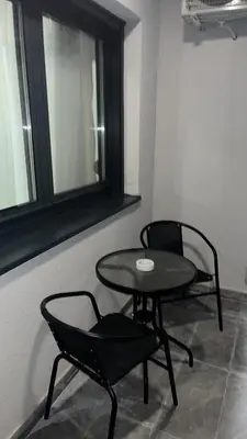 a table and chairs in a room with a window at APARTMAN PLAVA LAGUNA -Crnjanski in Jagodina