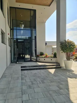 a building with a large glass door and a courtyard at APARTMAN PLAVA LAGUNA -Crnjanski in Jagodina