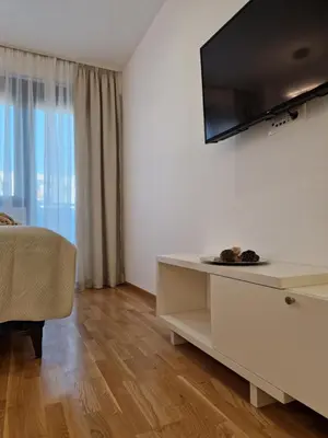 a living room with a tv on a wall at APARTMAN PLAVA LAGUNA -Crnjanski in Jagodina