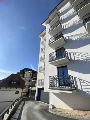 a white building with balconies on the side of it at Lawa Apartments Kopaonik in Cajetina