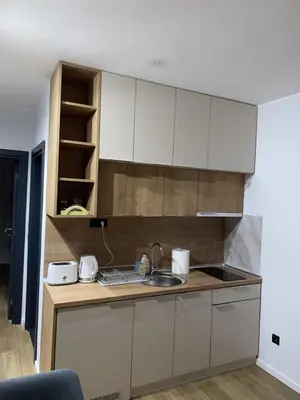 a kitchen with white cabinets and a sink at Lawa Apartments Kopaonik in Cajetina