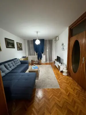 a living room with a blue couch and a table at Apartman Ristić in Pirot