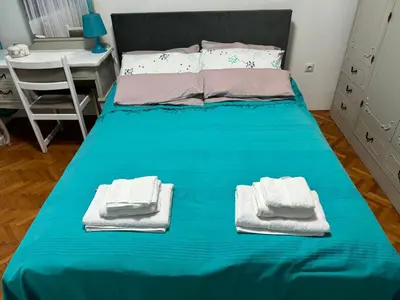 a blue bed with towels on it in a bedroom at Apartman Ristić in Pirot