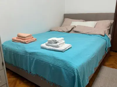 a bed with blue sheets and towels on it at Apartman Ristić in Pirot