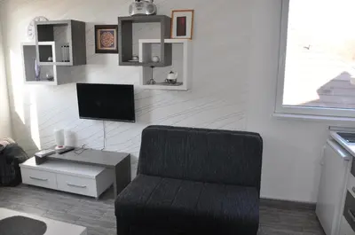 a living room with a chair and a television at Studio SimpaKop in Kopaonik