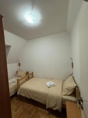 a small bedroom with two beds and a lamp at Apartmani Čardaci Kopaonik in Kopaonik