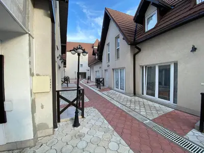 an alley between two buildings with a red brick sidewalk at Apartmani Čardaci Kopaonik in Kopaonik
