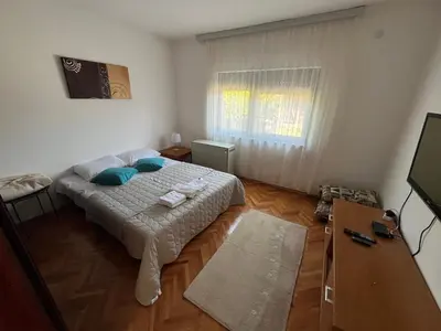 a bedroom with a bed with blue pillows in it at Domacinstvo Markovic in Prekopčelica