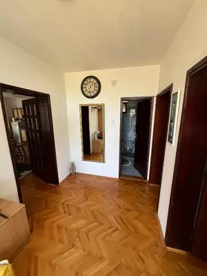 a room with a clock on the wall and wooden floors at Domacinstvo Markovic in Prekopčelica
