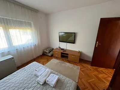 a bedroom with a bed and a television on a dresser at Domacinstvo Markovic in Prekopčelica