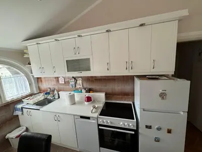 a kitchen with white cabinets and a white refrigerator at Mimis place in Vrnjačka Banja