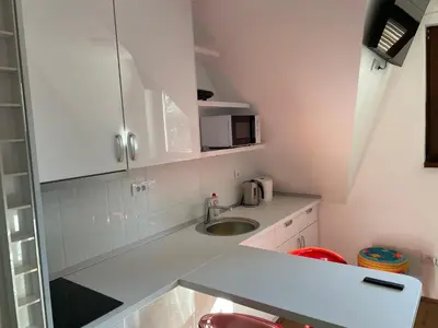 a white kitchen with a sink and a microwave at Apartments Sia-M3 in Kopaonik