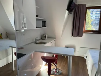 a small white kitchen with a counter and a sink at Apartments Sia-M3 in Kopaonik
