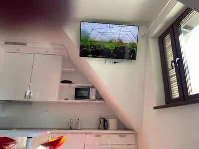 a kitchen with a tv hanging on the wall at Apartments Sia-M3 in Kopaonik