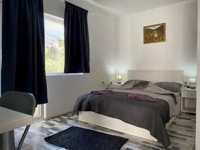 a bedroom with a large bed and a window at Studio Zverko in Soko Banja