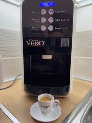 a cup of coffee in front of a coffee maker at Apartman Petrovic in Vranje