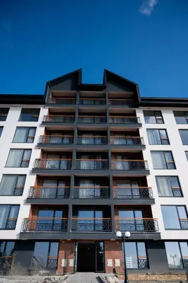 an apartment building with balconies and a blue sky at Residence Hill A037 Apartment in Kopaonik