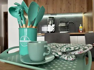a table with a coffee cup and utensils on it at Apartman Magdalena Kopaonik in Cajetina