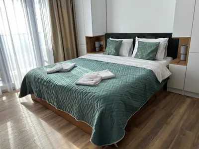 a bedroom with a large bed with two towels on it at Apartman Magdalena Kopaonik in Cajetina