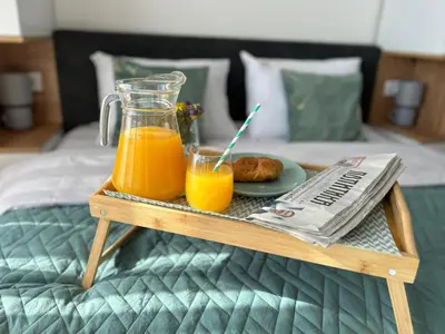 a tray with two glasses of orange juice and a newspaper at Apartman Magdalena Kopaonik in Cajetina
